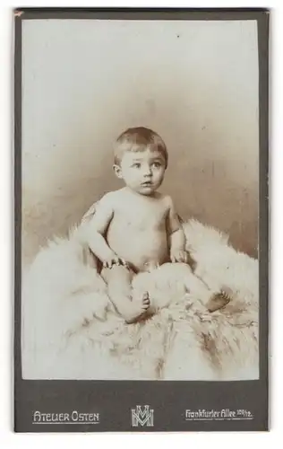 Fotografie Atelier Osten, Berlin, Frankfurter Allee 109 /12, Nacktes Kleinkind sitzt auf einem Schaffell