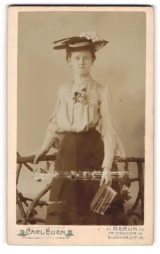 Fotografie Carl Euen, Berlin, Friesenstrasse 14, Modisch gekleidete junge Frau mit Hut und Buch