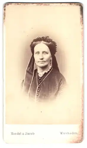 Fotografie Mondel & Jacob, Wiesbaden, Portrait betagte Dame mit Brosche & Halskette wohl gekleidet