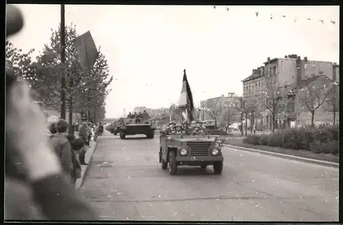 Fotografie NVA-Militärparade, Kübelwagen mit Nationalfahne führt Panzer, Tank-Kolonne an