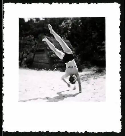 Fotografie Bademode, sportliche Frau im Bikini beim Handstand am Strand
