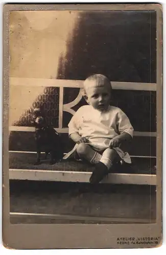 Fotografie Atelier Victoria, Herne i. W., Bahnhofstr. 78, Kleines Kind im weissen Kleid mit Spielzeughund
