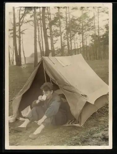 Fotografie Camping - Zelten, Bursche an seinem Zelt sitzend, koloriert