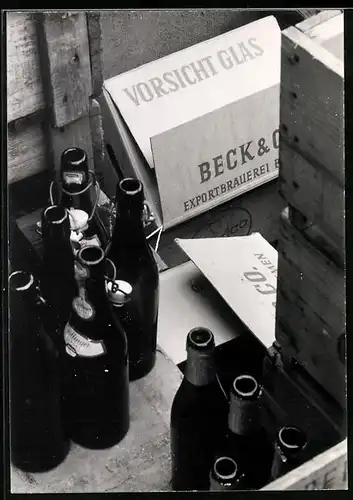 Fotografie leere Bier - und Weinflaschen neben Kisten der Beck's Brauerei