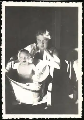 Fotografie Mutter badet Baby im Zuber