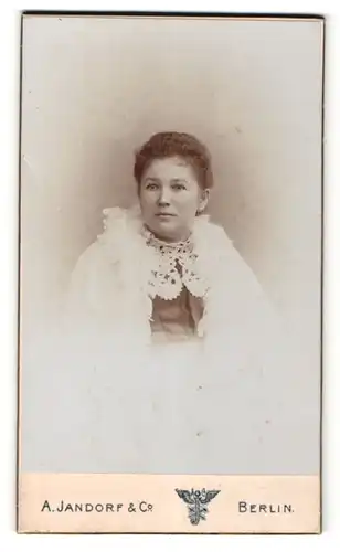 Fotografie A. Jandorf & Co., Berlin, Portrait dunkelhaarige Frau in weisser Jacke