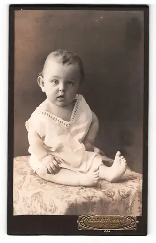 Fotografie Adalbert Werner, München, Portrait niedliches Kleinkind auf einem Tisch