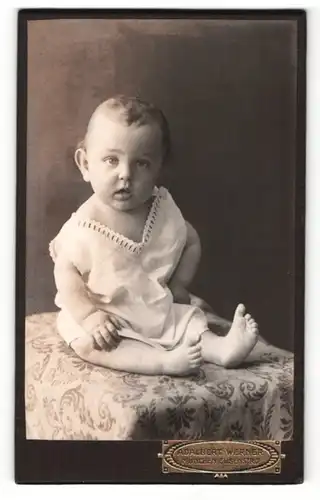 Fotografie Adalbert Werner, München, Portrait niedliches Kleinkind auf einem Tisch