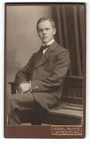 Fotografie Carl Ruhe, Langenthal, Portrait junger Herr im Anzug auf einer Bank