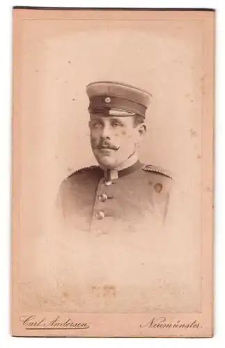Fotografie Carl Andersen, Neumünster, Portrait Soldat in Uniform mit Schirmmütze und Zwirbelbart