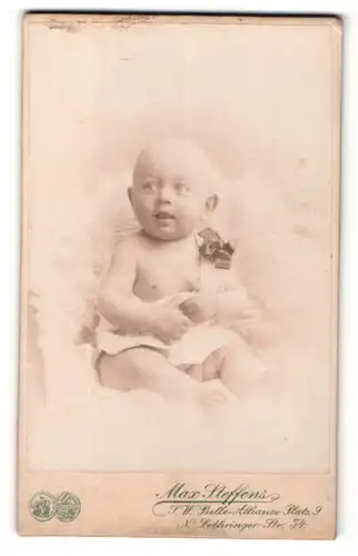 Fotografie Max Steffens, Berlin, Portrait sitzendes Baby im weissen Hemd mit Schleifchen