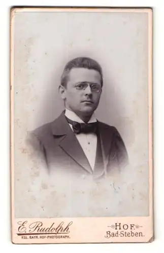 Fotografie E. Rudolph, Hof, Portrait junger Herr im Anzug mit Fliege und Zwicker