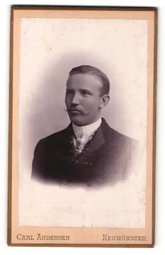 Fotografie Carl Andersen, Neumünster, Portrait elegant gekleideter Herr mit Zwirbelbart