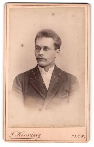 Fotografie F. Henning, Plön, Portrait modisch gekleideter Herr mit Brille und Schnurrbart