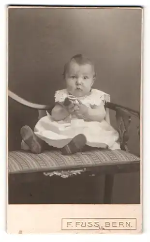 Fotografie F. Fuss, Bern, Portrait süsses Baby im niedlichen Kleid