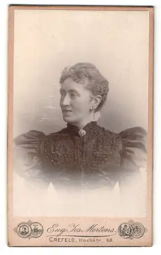 Fotografie Eug. Jos. Mertens, Crefeld, Portrait charmante Frau im bestickten Kleid