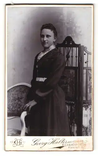 Fotografie Georg Haltermann, Eckernförde, Portrait elegant gekleidete Dame an Stuhl gelehnt