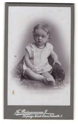 Fotografie Friedr. Brüggemann, Leipzig-Neustadt, Kleinkind im weissen Hemdchen, auf einem Sessel sitzend