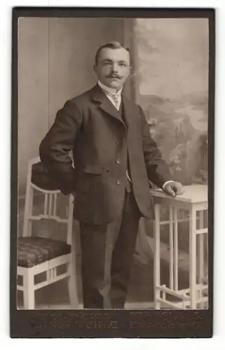 Fotografie Ernst Oehme, Freiberg i / S, Portrait elegant gekleideter Herr an Tisch gelehnt