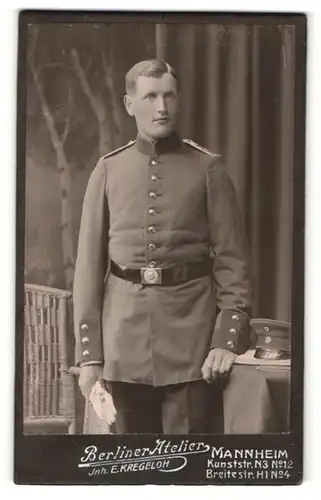 Fotografie E. Kregeloh, Mannheim, Portrait Soldat in Uniform mit Handschuhen und Schirmmütze