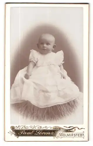 Fotografie Paul Lorenz, Wolmirstedt, Portrait niedliches Baby im weissen Kleidchen