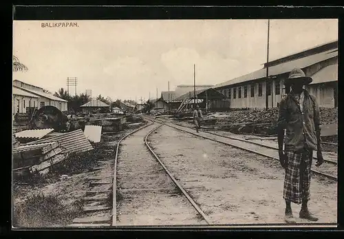 AK Balikpapan, Bahnschienen zwischen Gebäuden, mit Passanten