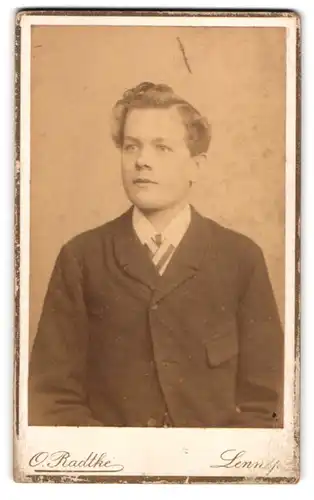 Fotografie Otto Radtke, Lennep, Junger Mann mit Locke und schwarzem Mantel