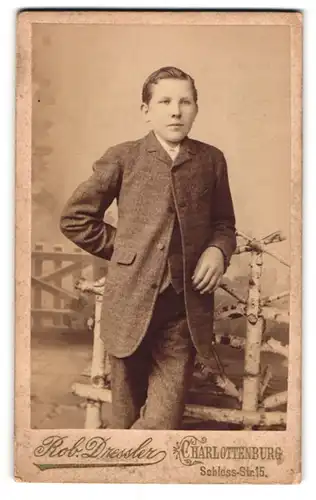 Fotografie Rob. Dressler, Charlottenburg, Schloss-Str. 15, Junger Bursche mit Seitenscheitel im grauen Anzug