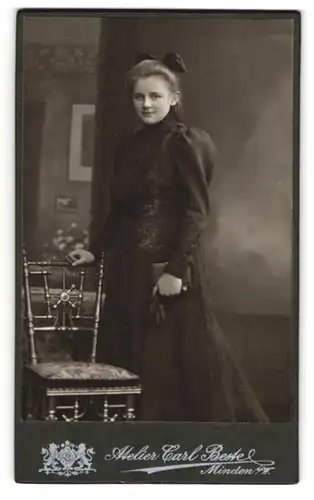 Fotografie Carl Beste, Minden i. W., Bäckerstr. 13, Junge Frau in schwarzem Kleid mit Schleife und Handschuhen