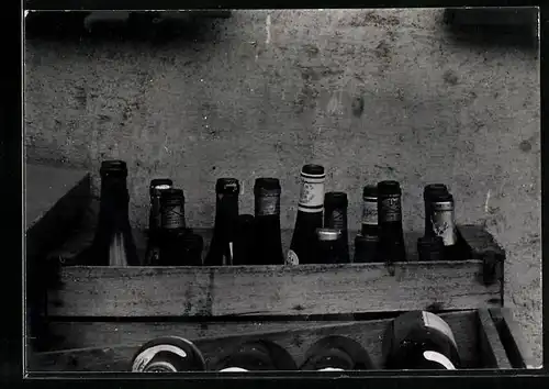 Fotografie Leergut, verschiedene leere Bier - und Weinflaschen in Holzkisten