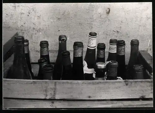 Fotografie Leergut, verschiedene leere Wein - und Bierflaschen in einer Holzkiste