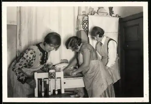 Fotografie Hausfrauen beim Backen, Teig wird mit Nudelholz ausgerollt