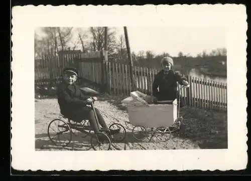 Fotografie Knabe mit Tretauto / Draisine & Mädchen mit Puppenwagen