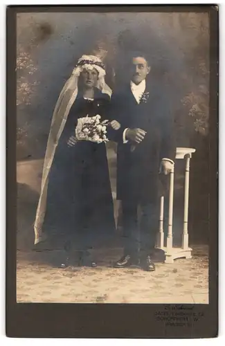 Fotografie C. Schmid, Basel, Feldbergerstr. 72, Hochzeitspaar im schwarzen Brautkleid und Anzug