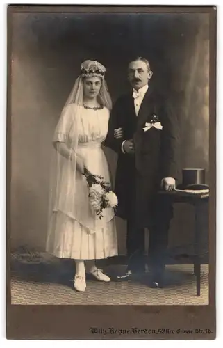 Fotografie Wilh., Behne, Verden a. Aller, Grosse Str. 76, Braut im Hochzeitskleid nebst Mann im Anzug mit Zylinder