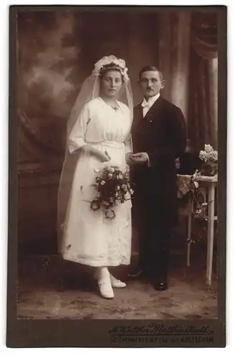 Fotografie M. Walther, Seifhennersdorf i. Sa., junges Brautpaar im Hochzeitskleid und Anzug halten Händchen