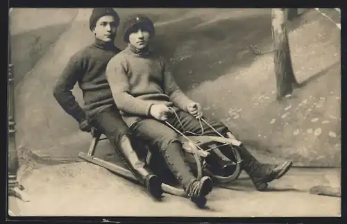 AK Zwei junge Männer auf einem Rodelschlitten