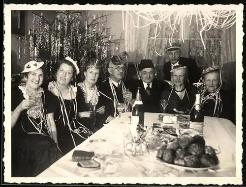 Fotografie Silvester - Neujahrsfeier, Feiergesellschaft vor Weihnachtsbaum sitzend