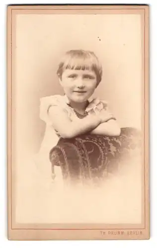Fotografie Th. Prümm, Berlin, Unter den Linden, Niedliches Kind in weissem Kleid mit geradem Pony und Perlenkette