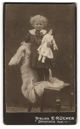 Fotografie E. Rücker, Zehdenick, niedliches kleine Mädchen mit ihrer Puppe im auf einem Stuhl
