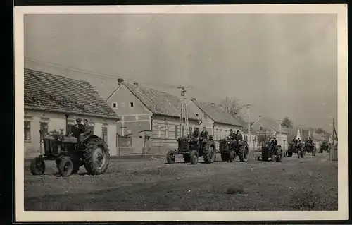 Fotografie Traktor, Ackerschlepper, Schlepper-Kolonne durchfährt Ortschaft
