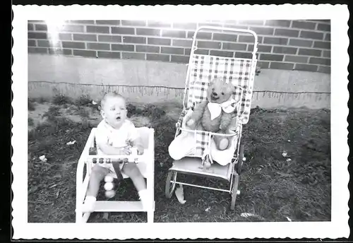 Fotografie Baby nebst Teddybär, Teddy, Teddybear im Kinderwagen sitzend