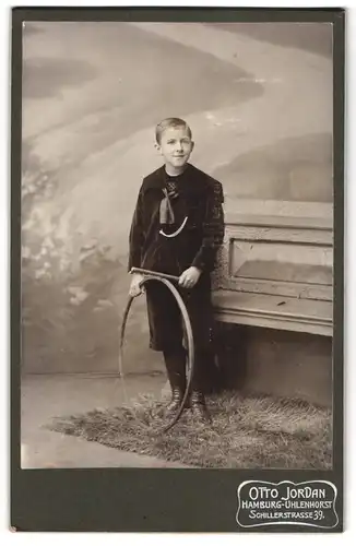 Fotografie Otto Jordan, Hamburg-Uhlenhorst, Schillerstr. 39, Junger Bursche in schwarzer Jacke mit Ringspielzeug