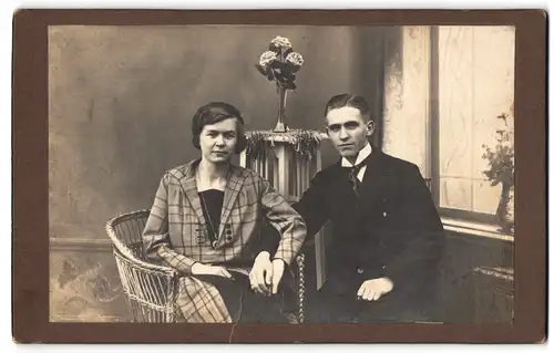 Fotografie Nybuis, Nordhorn, Junges bürgerliches Paar in eleganter Kleidung mit Rosenstrauss
