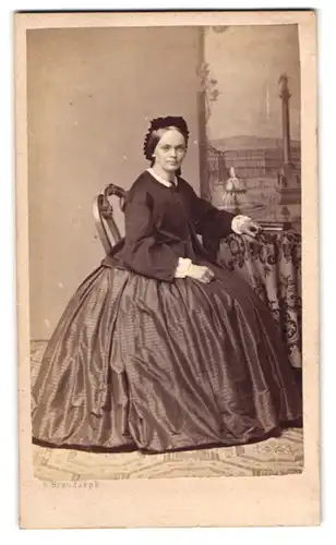 Fotografie F. Brandseph, Stuttgart, junge Dame mit Reifrock und Blousson vor einer Studiokulisse des Schlossplatz