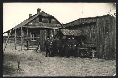 Foto-AK Telecheny, Soldaten in Uniform vor Holzhäusern
