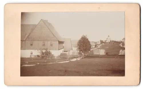 Fotografie unbekannter Fotograf, Ansicht Zinnwald-Georgenfeld, Blick von einem Gutshaus nach der Kirche