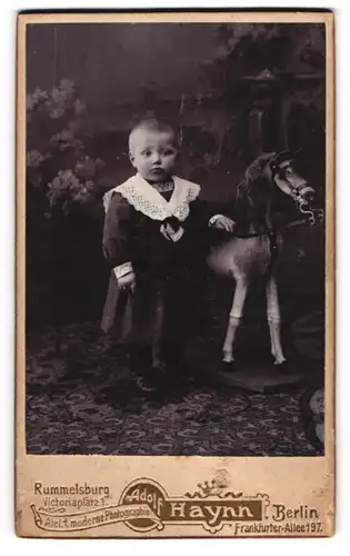 Fotografie Adolf Haynn, Berlin, niedliches Kind im Kleid mit Holz Schaukelpferd