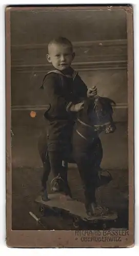 Fotografie Richard Bassler, Oberoderwitz, niedlicher Knabe Herbert Ullrich auf seinem Holz Pferd samt Rollen