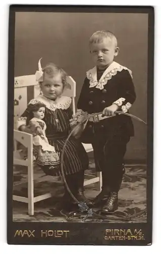 Fotografie Max Holdt, Pirna a. E., junger Knabe mit seiner Schwester samt Puppe auf einer Bank